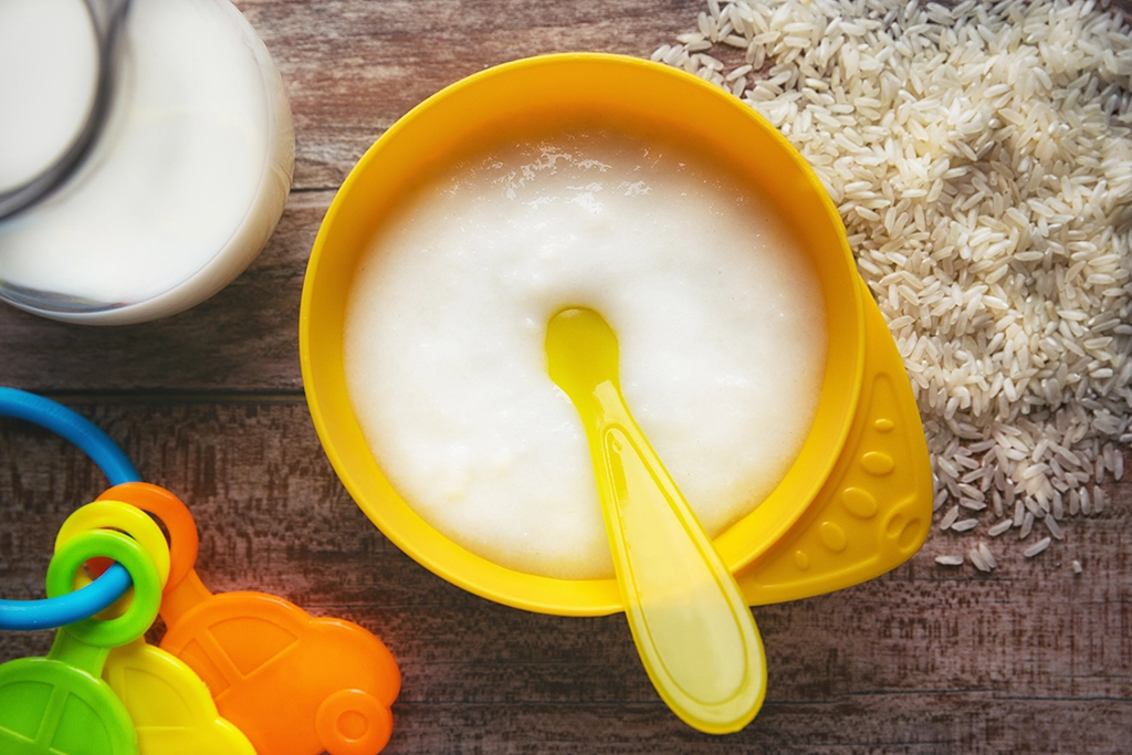 Rice-based baby food in yellow bowl. 