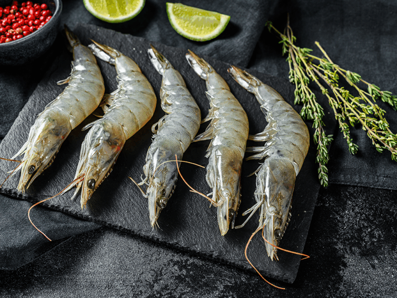 Shrimp arranged on a cutting board for seafood testing.