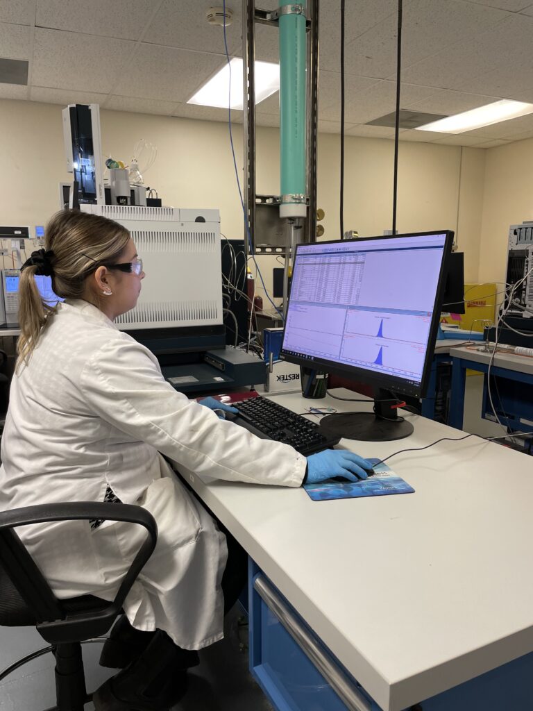 Scientist viewing results of food testing assay on a computer screen. 