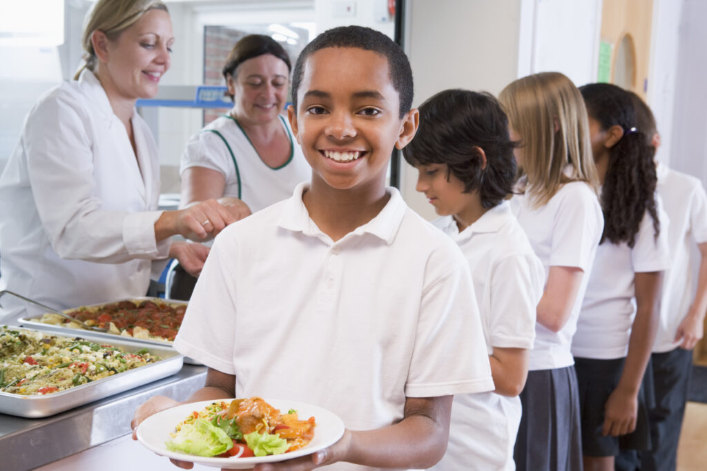 Students in line with trays for school lunch.